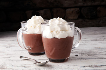 Hot chocolate or coffee with whipped cream in glass.