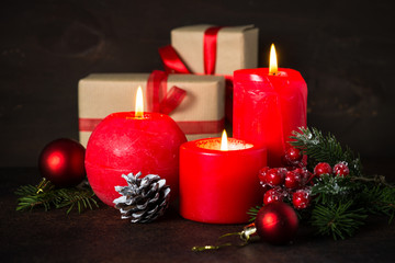 Red christmas candle and present on dark.