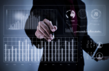 Obraz na płótnie Canvas Businessman on blurred background writing with a pen on a digital screen