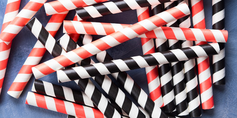 Red and black striped straws background. Party cocktail concept