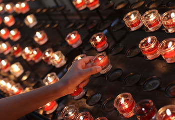 little girl takes a candle in the church during the holy Mass