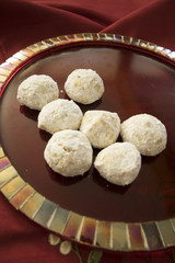 Buttery almond cookies on red mosaic tile plate