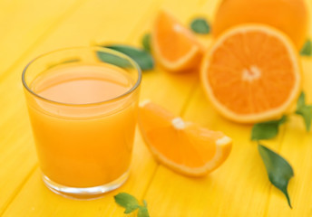 Glass of fresh orange juice on table