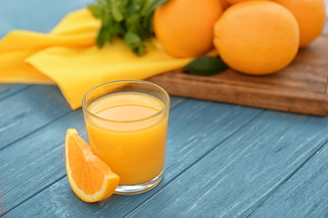 Glass of fresh orange juice on table