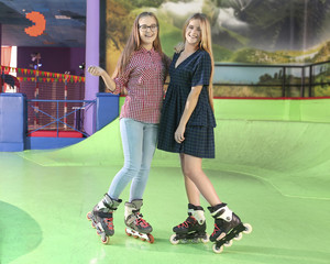 Charming teenage girls at roller skating rink