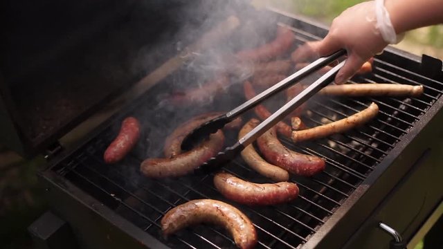 Cooks grilled sausages.