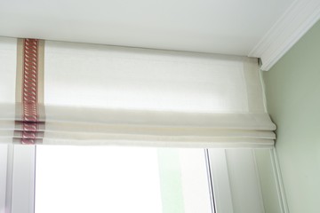 Roman curtains in the interior. From natural light linen, with decorative braid.