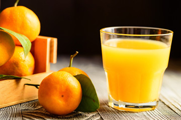 Glass of fresh juice and mandarins on table