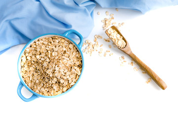 Oat flakes plate with milk, orange, eggs on a wooden white table. Top view of healthy oat flakes breakfast. Copy space. blue napkin Breakfast in bed plate, breakfast table buffet. Healthy ingredients