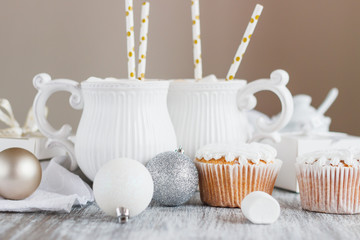 Cups with cacao and marshmallow, cupcakes and different Christmas decorations