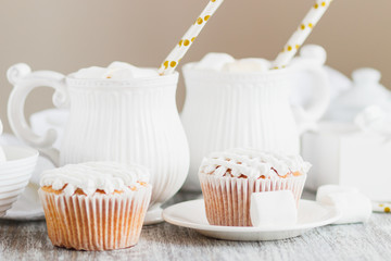 Cups with cacao and marshmallow, cupcakes and different decorations