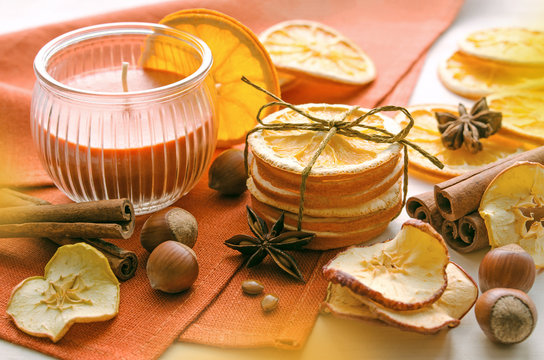 dried oranges and apples, anise stars, nuts, cinnamon sticks and aroma candle