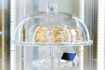 piece cake Napoleon in a glass case in a showcase coffee houses