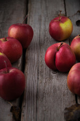 Red fresh apples on a wooden background scattered