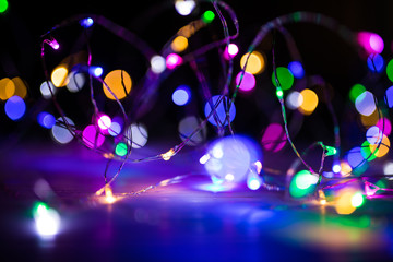 Disfocused blurred Christmas bokeh lights over dark background