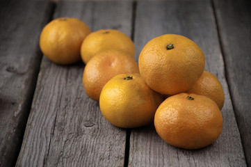On a wooden background a bunch of fresh mandarins