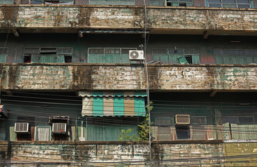 Outside view of an ran down green apartment building with balconies in Bangkok, Thailand