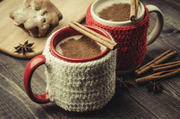 Traditional winter eggnog in decorative mugs with cinnamon/Traditional winter eggnog in decorative mugs with cinnamon on a dark background. Selective focus