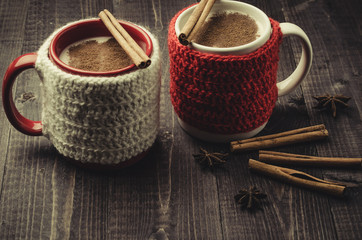 Traditional winter eggnog in decorative mugs with cinnamon/Traditional winter eggnog in decorative mugs with cinnamon on a dark background