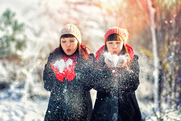 Mom and daughter play with snow