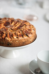 Fresh homemade apple cake on a laid table with white table cloth