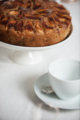 Fresh homemade apple cake on a laid table with white table cloth