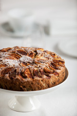 Fresh homemade apple cake on a laid table with white table cloth