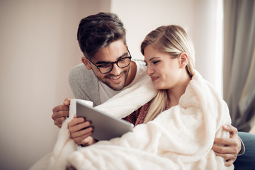 Young couple using a tablet at home