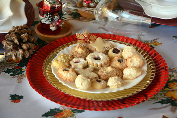 Christmas cookies with nuts, jam and coconut decorated on a plate on a table. 