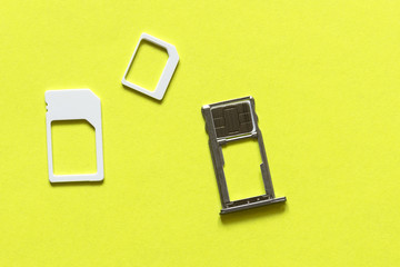 Adapters on a SIM card from larger to nano-sim with a SIM card in the slot, close up