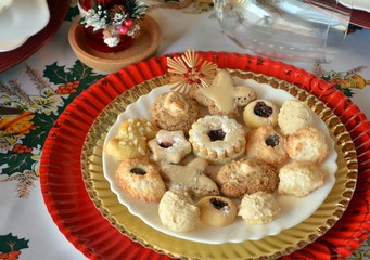 Christmas cookies with nuts, jam and coconut decorated on a plate on a table. 