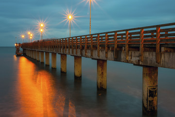 Fototapeta premium pier and a beautiful cloudy sky above the sea, long exposure