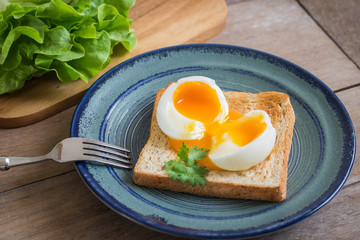Soft boiled egg with toast on blue plate