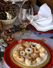 Lovely close up image of Christmas cookies decorated on a red plate on a table.
