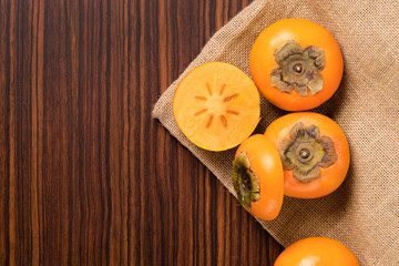 Persimmon fruit on rustic sack and wooden table