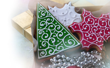 Christmas gingerbreads in the form of white and red snowflakes and a green fir-tree on white background