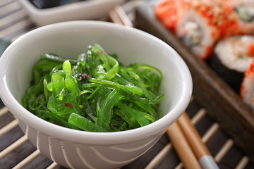 Bowl with green chuka algae on table