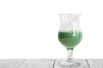 Glass of wheat grass juice on white background