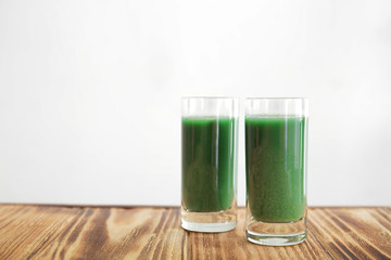 Shots of wheat grass juice on white background