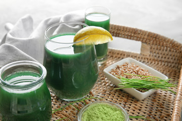 Glasses of wheat grass juice on wicker tray