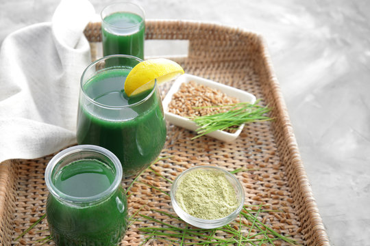 Glasses of wheat grass juice on wicker tray