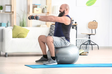 Fototapeta na wymiar Overweight man doing exercises at home