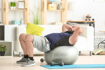 Overweight man doing exercises at home
