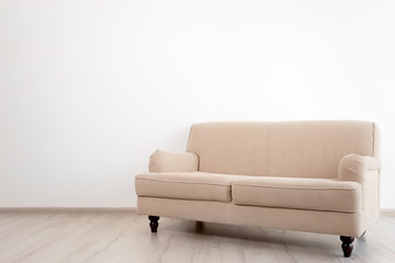Stylish sofa on white wall background