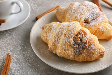 Plate with tasty croissants on table, closeup