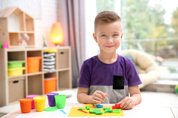 Little boy engaged in playdough modeling at daycare