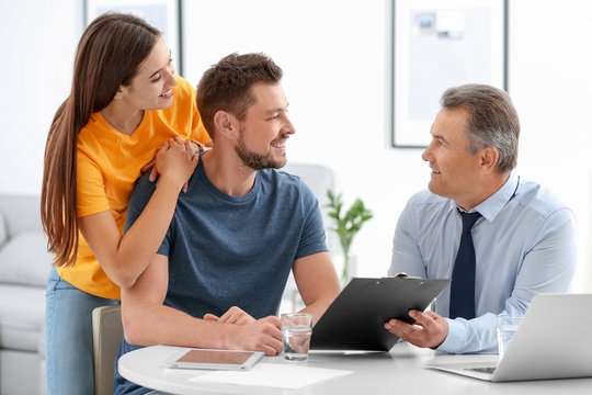 Male insurance agent consulting young couple in office