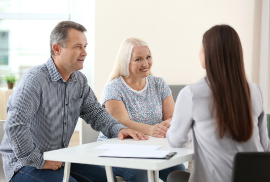 Female insurance agent consulting senior couple in office