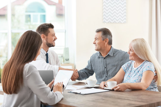 Insurance agents consulting senior couple in office