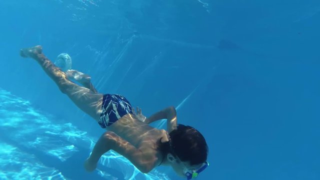 Boy dive in swimming pool, underwater shoot